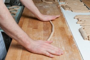 Dinkelbretzeln werden (beinahe im Sekundentakt) von Hand gedreht