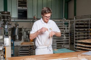 Hier wird eines der badischen Grundnahrungsmittel von Hand gedreht: Bretzelproduktion