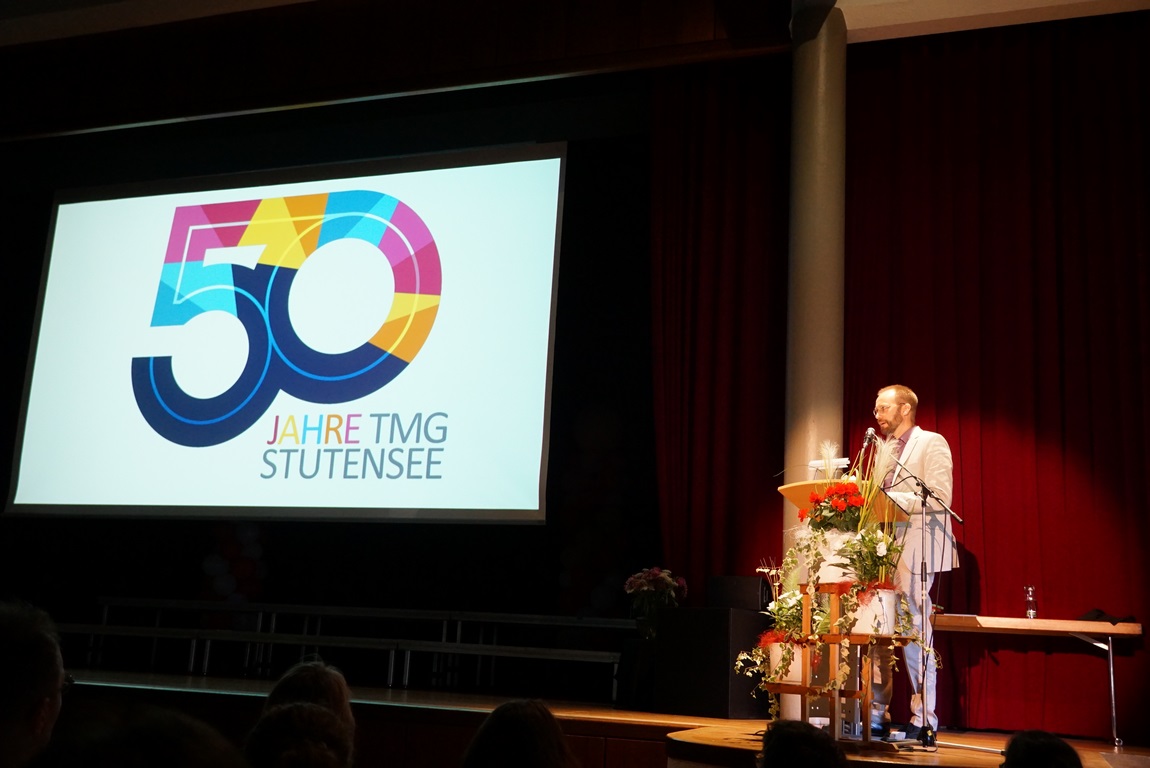 Schulleiter Christian Beck und das Jubiläumslogo